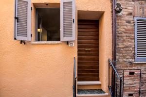 een gebouw met een deur, een raam en een trap bij Casa Nella in Urbino