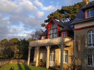 a house with a balcony on the front of it at Roch'ar piguet in Carantec