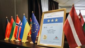 a table with flags and a sign on it at Bella Riga Hotel with Self-Check in in Riga