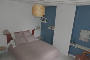 - une chambre avec un lit et un mur bleu dans l'établissement Belval Cottages, à Bénouville