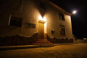 een gebouw met een deur die 's nachts verlicht is bij Cueva Pura Vida in Pulpite