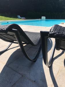 un sillón negro junto a la piscina en Chateau Pont Jarno B&B en Champdeniers-Saint-Denis