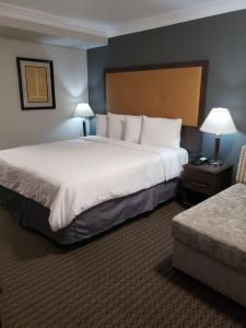 a hotel room with a large bed and a chair at Portofino Inn Burbank in Burbank