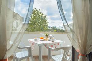 een witte tafel met 2 stoelen en een tafel met sinaasappelsap bij Residence Borgo Latino- Localo in Torre dell'Orso