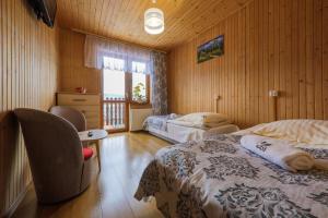 ブコビナ・タトシャンスカにあるGórski Ośrodek Jeździeckiのベッドルーム1室(ベッド2台、椅子付)