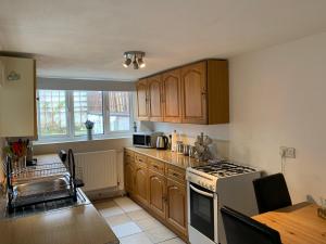 a kitchen with wooden cabinets and a stove top oven at Winstanley House in Wellingborough