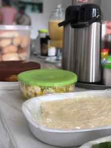 a bowl of food with a green lid on a counter at Pousada Rio Alegre in Santo Amaro