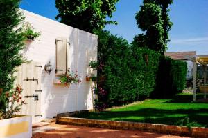 Una casa blanca con flores a un lado. en Villa La Lolliana, en Monestirolo