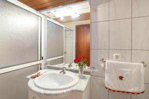 een badkamer met een wastafel en een spiegel bij Apartment lucy in Arco da Calheta +29 foto's
