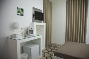 a room with a bed and a tv on a fireplace at VILLA ADELAIDE SUITE & ROOM in Torre a Mare