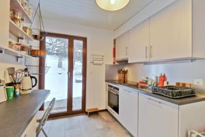 una cucina con mobili bianchi e un piano di lavoro di Modern and well equipped apartment, 500m from the 4 Vallées ski area ad Agettes Altre 11 foto