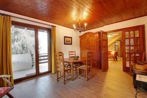 comedor con mesa, sillas y ventana en Modern and well equipped apartment, 500m from the 4 Vallées ski area, en Agettes