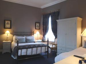 a bedroom with a bed and a dresser and a window at O'Neills Victorian Pub & Townhouse in Dublin