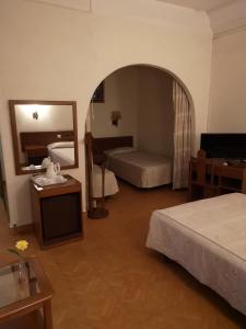 a hotel room with two beds and a mirror at Hotel Nazareth in Lisbon