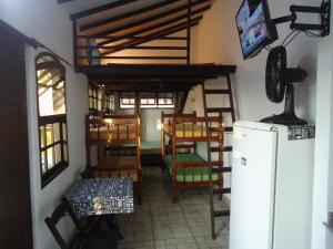 Vila do Sossego في كابو فريو: غرفة بها كراسي وثلاجة في الغرفة