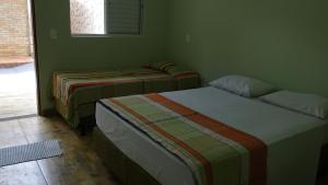 2 camas en una habitación con paredes verdes en Casa da Dinda, en Pirenópolis