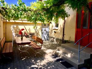 eine Terrasse mit einem Tisch und Stühlen unter einem Baum in der Unterkunft Margaréta Vendégház in Fehérvárcsurgó