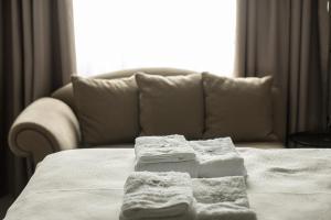a bed with towels on it with a couch at Urban Living 2 in Thessaloniki