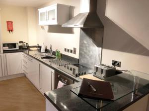 a kitchen with white cabinets and a counter top at Central Darlington Central 2BR Apartment in Darlington