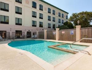 a large swimming pool in front of a building at Wingate by Wyndham Bossier City in Bossier City