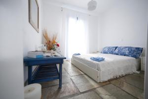 a bedroom with a bed and a table and a window at Serenity Kythnos in Kithnos