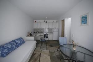 a living room with a white couch and a glass table at Serenity Kythnos in Kithnos