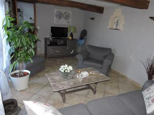a living room with a couch and a coffee table at Gîte de la Ferme de la Côte in Les Damps