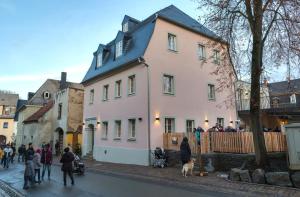 Un groupe de personnes se tenant devant une grande maison blanche dans l'établissement Boutique Hotel grüner Zweig, à Schlettau