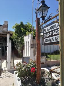 una luz de la calle frente a un edificio con un cartel en Alojamiento Turistico Mainque, en Las Grutas