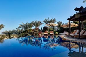 a pool at a resort with chairs and umbrellas at Lazibinn Boutique Hotel in Tunis