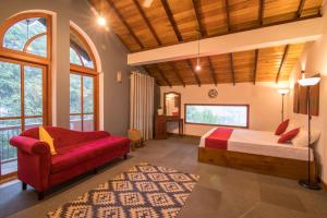 a bedroom with a bed and a couch in a room at Estancia Holiday Bungalow in Matale