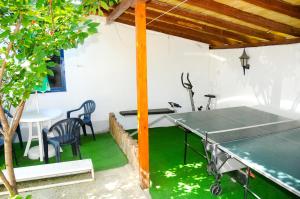 a ping pong table in a room with a table and chairs at Andi Hotel in Chernomorets