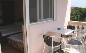 una mesa y sillas en un balcón con ventana en Di Vincenzo Inn, en Ulcinj