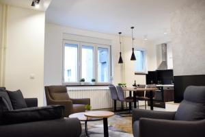 a living room with chairs and a table and a kitchen at Apartments Belvedere in Belgrade