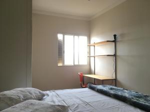 a bedroom with a bed and a window and a shelf at RelaxRP in Ribeirão Preto