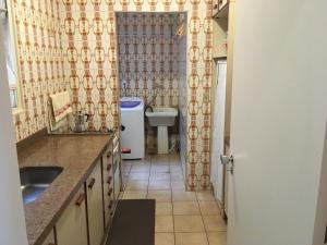 a kitchen with a sink and a refrigerator at RelaxRP in Ribeirão Preto +21 photos