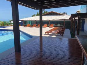 a patio with benches and a swimming pool at Gabrielly Praia Hotel in Guaibim +13 photos