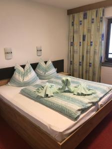 a bed with two pillows on top of it at Gastehaus Egger in Mittersill