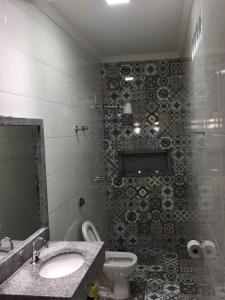 a bathroom with a toilet and a sink and a mirror at Bom Jardim in Piauí