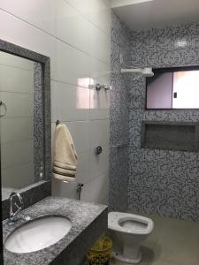 uma casa de banho com um lavatório e um WC em Bom Jardim em Piumhi