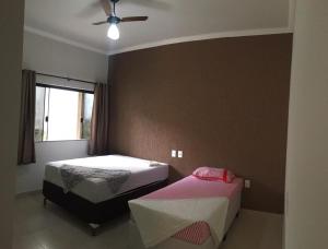 um quarto com 2 camas e uma ventoinha de tecto em Bom Jardim em Piumhi