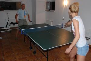 a man and a young girl playing a table tennis at Pensiunea Aurora Izvorul Muntelui in Bicaz