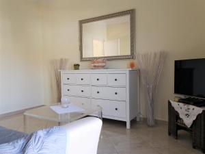 ein Wohnzimmer mit einer weißen Kommode und einem Spiegel in der Unterkunft Emotion Apartments in Asprovalta