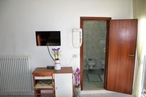 a bathroom with a table and a toilet and a television at Hotel Ristorante Da Marco in San Mauro a Mare