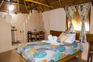a bedroom with a bed with a flower on it at Veleando Ando Cabañas in Bacalar