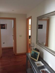 een woonkamer met een spiegel en een tafel bij Villa de Madrid 17 in Huelva