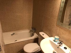 een badkamer met een wastafel, een toilet en een bad bij Villa de Madrid 17 in Huelva