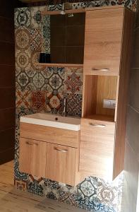 een badkamer met een wastafel en een tegelwand bij B&BbyBerry in Lieshout