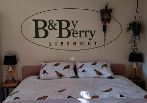 a bedroom with a bed with a large sign on the wall at B&BbyBerry in Lieshout