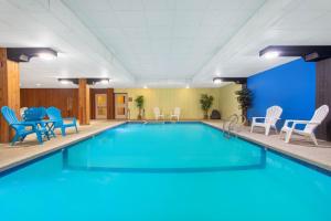 a large swimming pool with blue chairs and chairs at Clarion Pointe Rhinelander Downtown in Rhinelander
